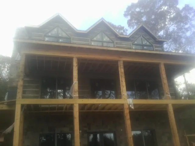 Dormers and porch framing on a large log home under construction — Roof Coating work by our crew in Grand Coulee