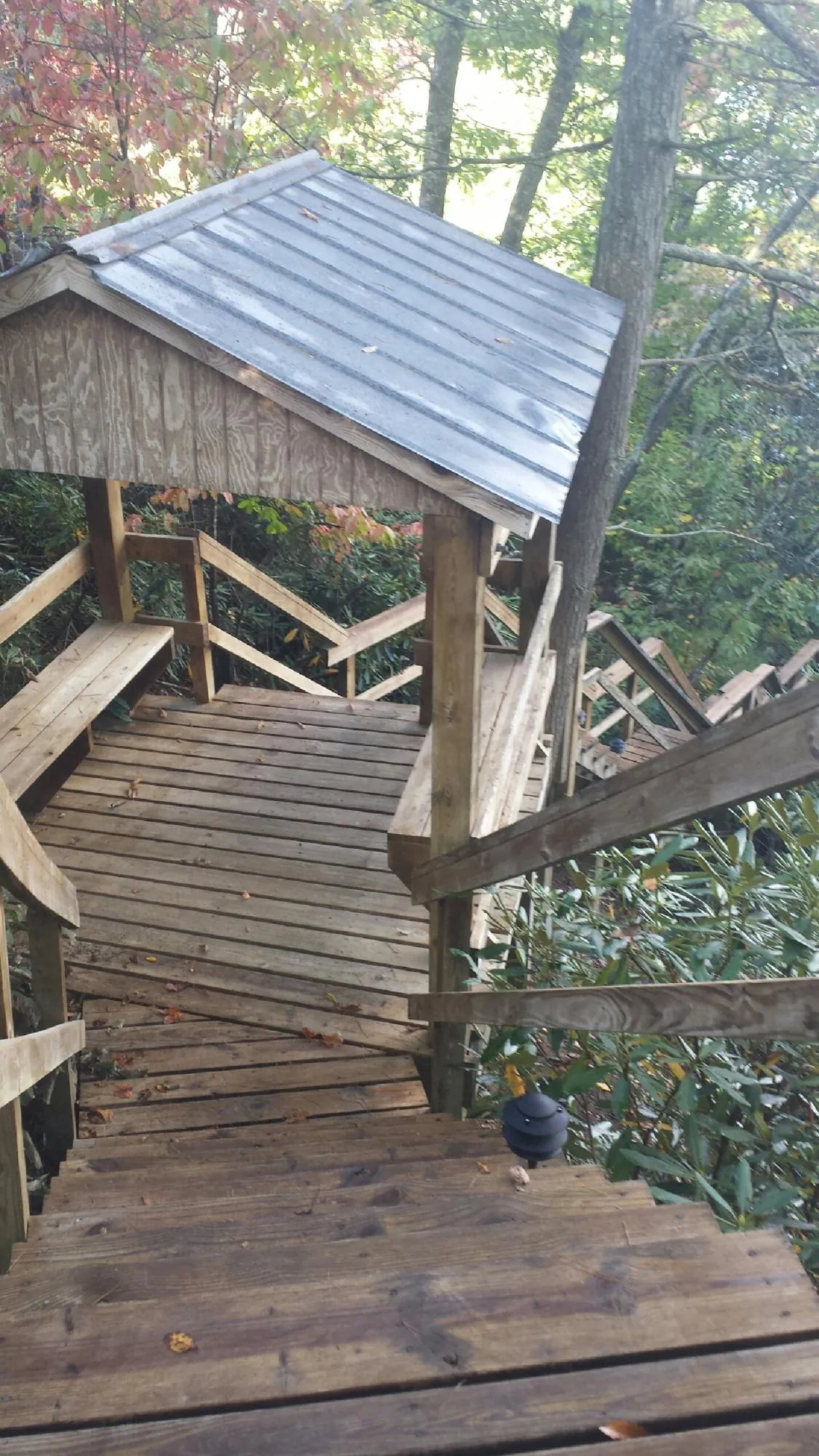Metal roofed shelter over wooden steps on a wooded walkway — Skylight Repair & Installation work by our crew in Grand Coulee
