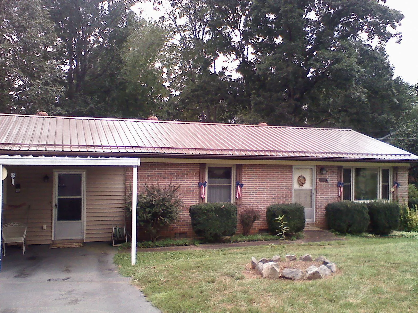 Bronze metal roof and carport on a brick ranch home — Roof Repair work by our crew in Grand Coulee